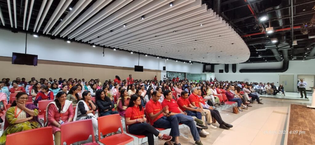 A team of individuals wearing red t-shirts in the front row of a larger audience.