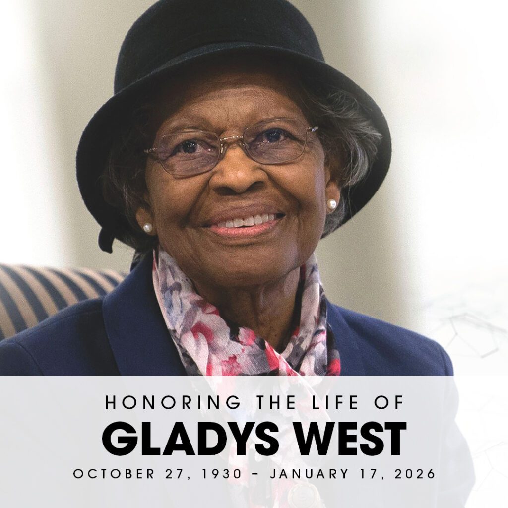 A photo of Gladys West smiling at the camera wearing a blazer, a floral scarf, and a black hat. Text reads "Honoring the life of Gladys West"