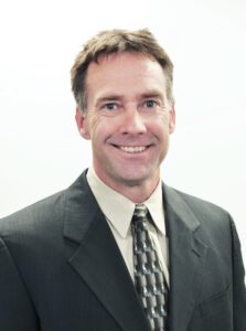 A headshot of Joe McBreen smiling at the camera