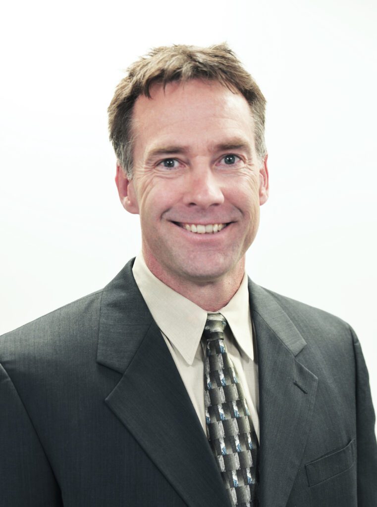 A headshot of Joe McBreen smiling at the camera