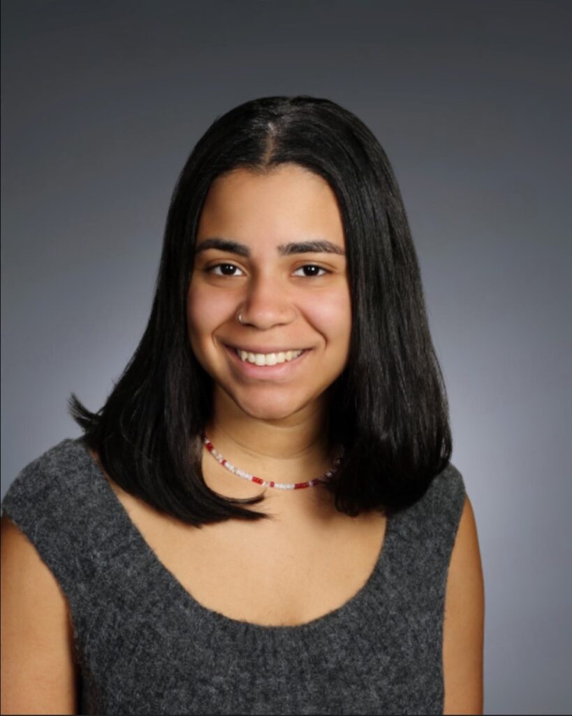 A headshot of Maria Cuevas smiling at the camera